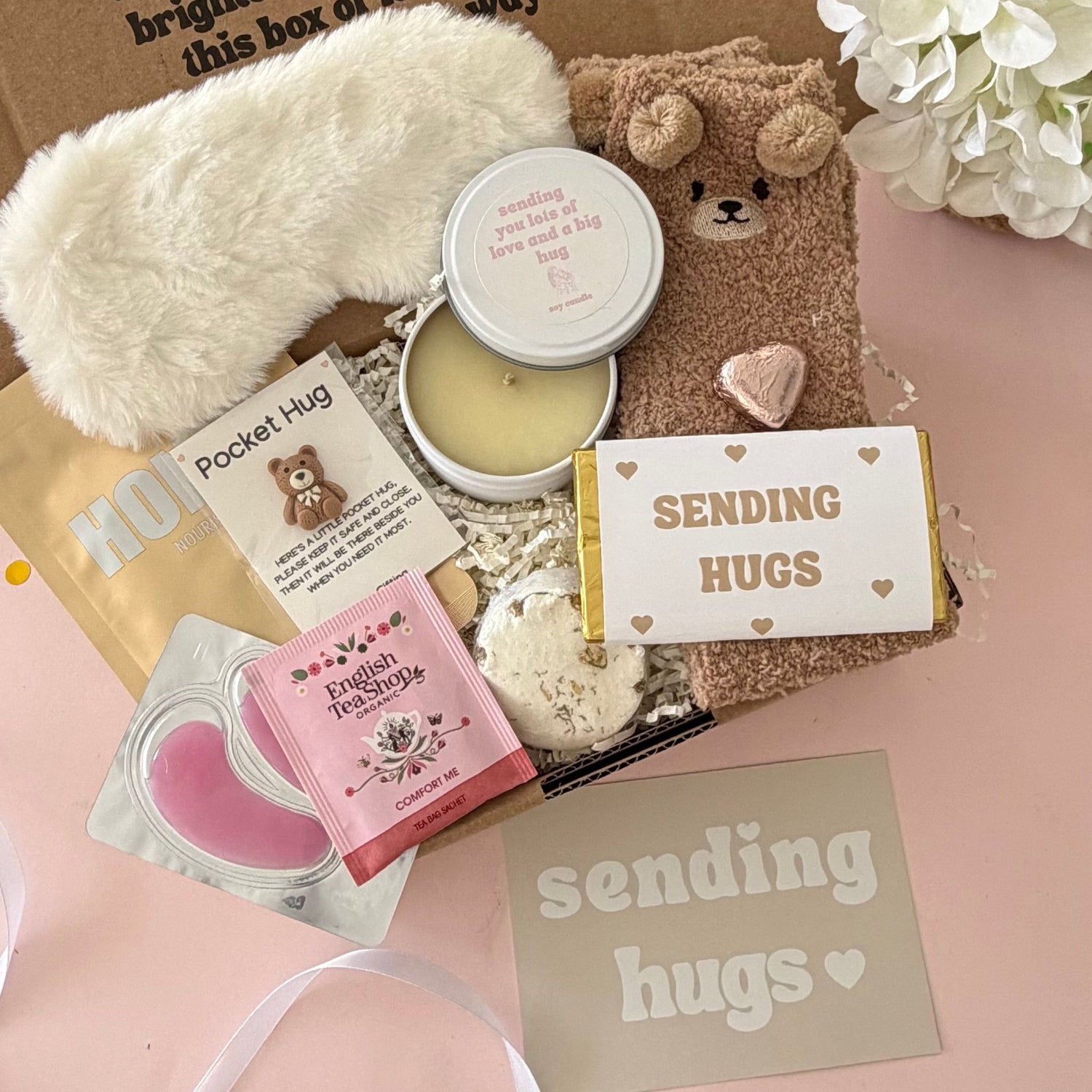 Sending Hugs Gift Box including candle, bear socks, lapcos facemask sheet, teabag, under eye, choc heart. shower steamer, bear pocket hug and Sending Hugs Chocolate