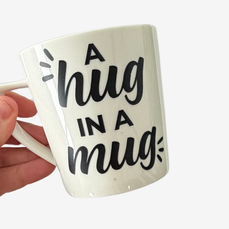 White ceramic Hug in a Mug cup with black lettering, a comforting gift for someone going through a difficult time