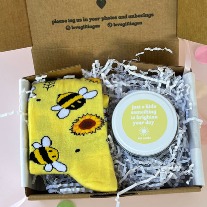 Gift box with a yellow sunflower and bee socks and a brighten your day yellow candle