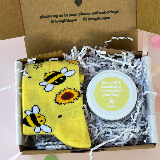 Gift box with a yellow sunflower and bee socks and a brighten your day yellow candle