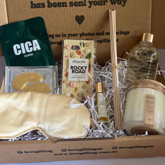 Corporate Gift box with various items including a sleep mask, soap, and a bottle, with a message on the box.