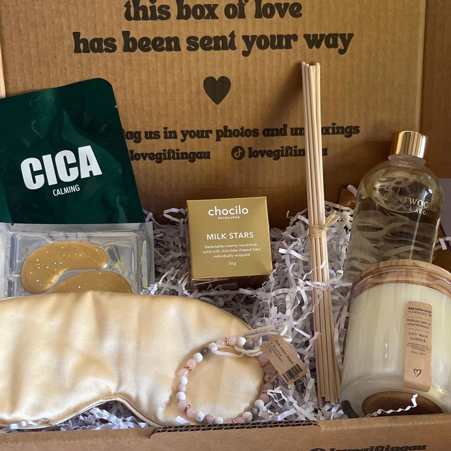 Gift box with various items including soap, a bottle, and a Cica product on a white background.