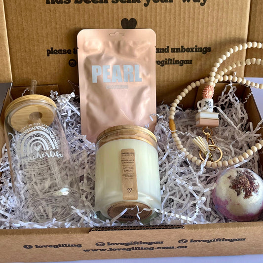 Gift box with a candle, facemask, and other items, featuring text on the box.