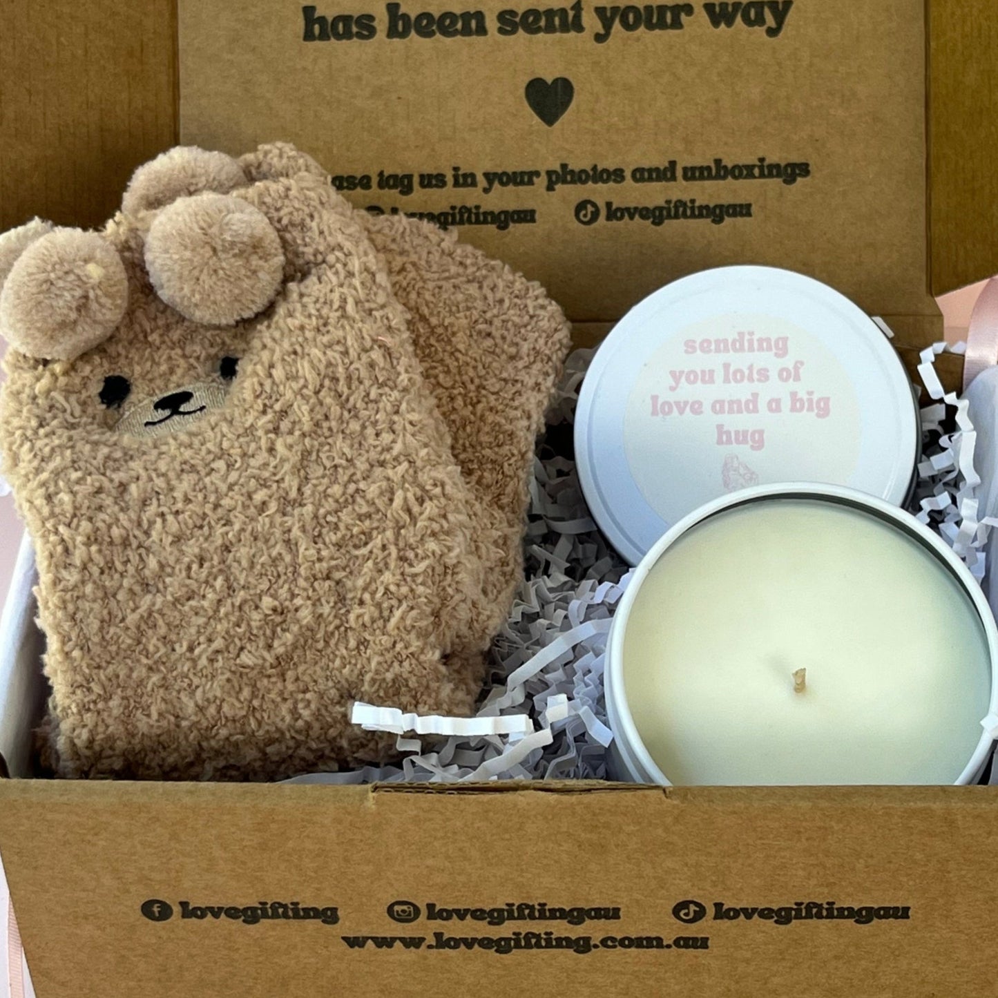 Candle in a box with a pair of brown bear socks