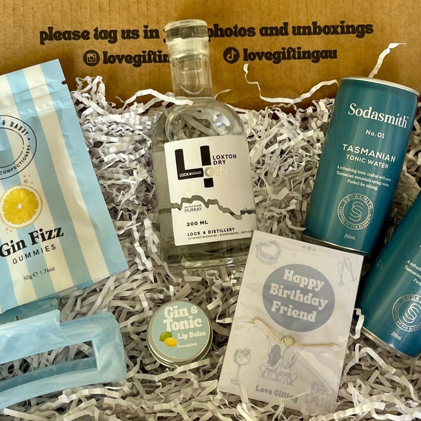 Gift box with various items including a bottle of Gin, Gin lollies, hair clip and Lipbalm 