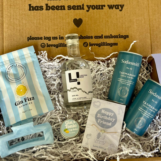 Gift box with various items including a bottle of Gin, Gin lollies, hair clip and Lipbalm 