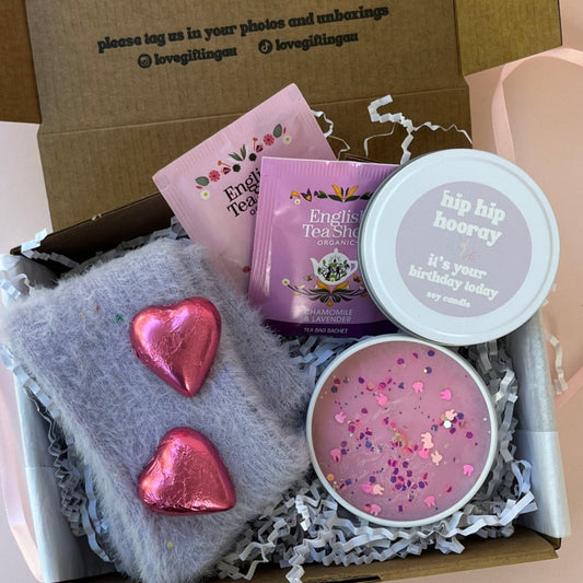 Gift box with purple socks, hip hooray candle, teabags and mini chocolate hearts.