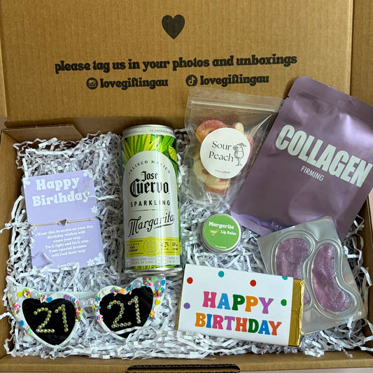 Gift box with birthday-themed items including a can of beer, a bottle of water, and a card inside.