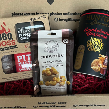 Gift box with snacks and a card on a plain background