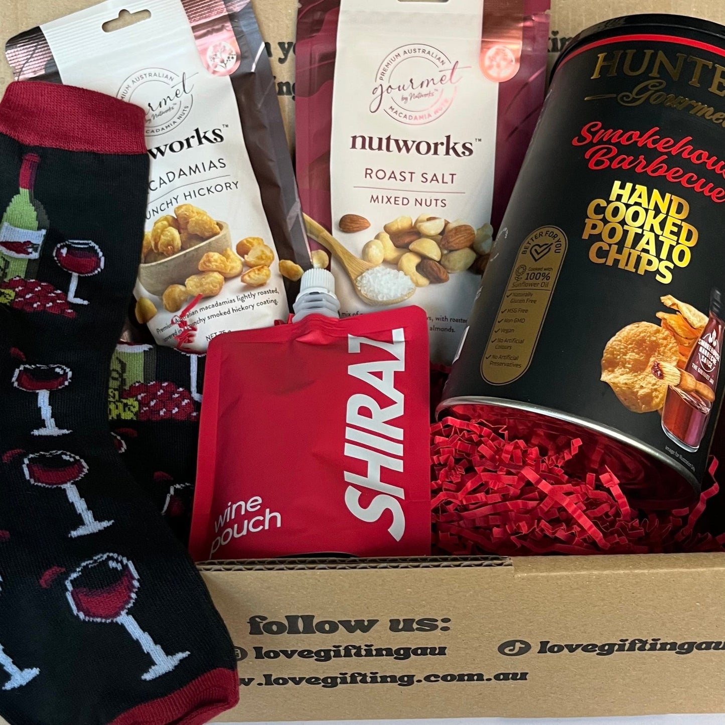 Gift box with snacks and a red pouch labeled 'Shiraz' on a white background