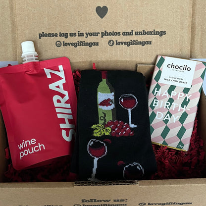 Box of love with wine-themed items including a pouch, socks, and a card.