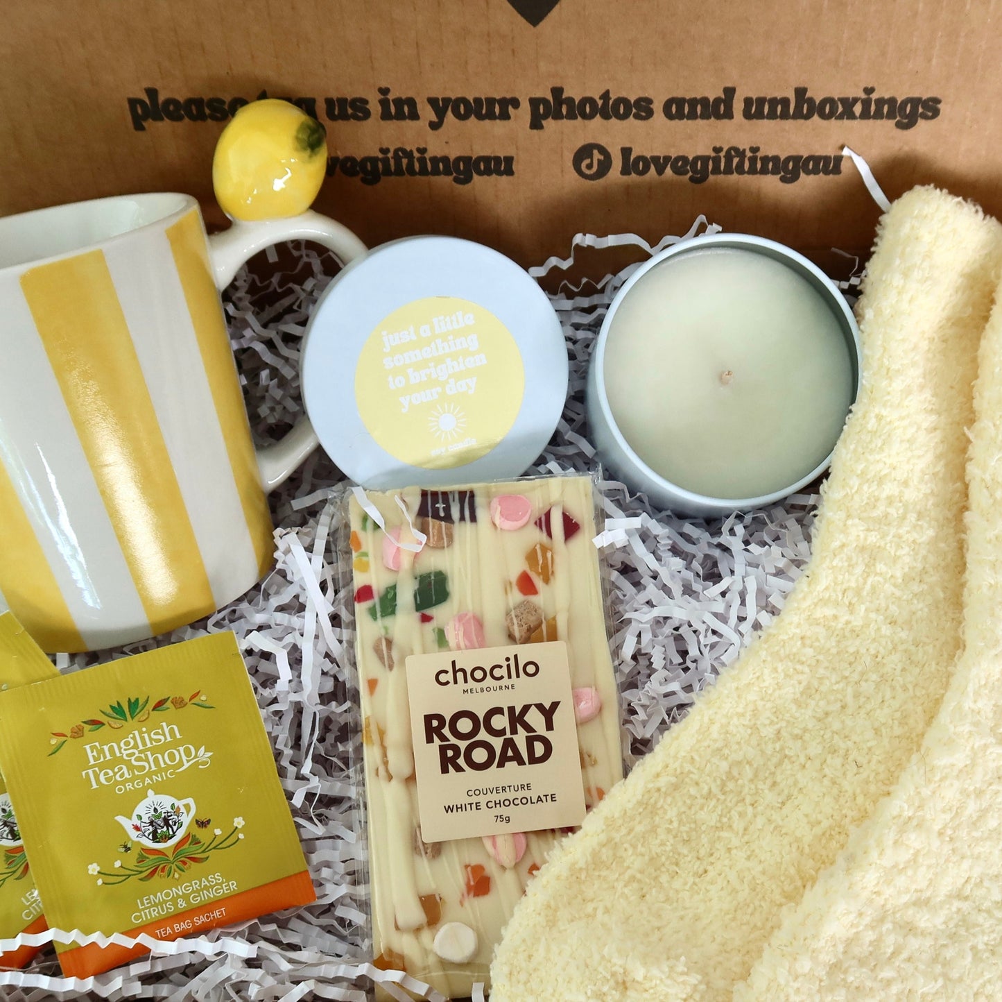 Gifting box with a mug, lemon, soap, candle, and Rocky Road chocolate bar.