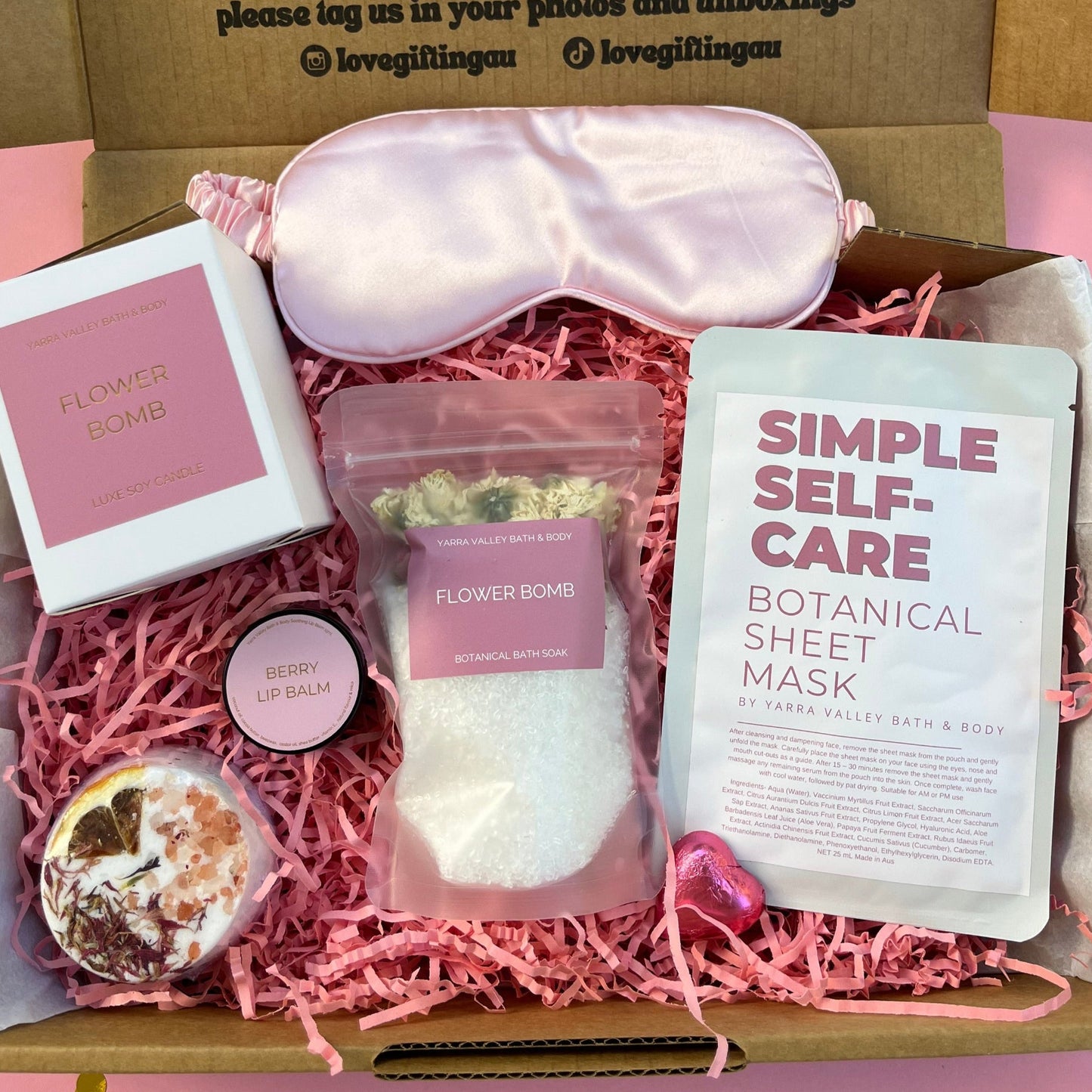 Self-care gift box with items including a sleep mask, botanical sheet mask, and bath bomb.