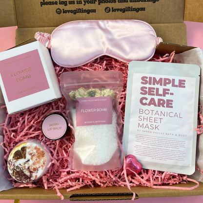 Self-care gift box with items including a sleep mask, botanical sheet mask, and bath bomb.
