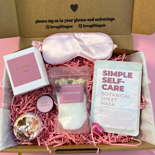 Self-care gift box with items including a sleep mask, botanical sheet mask, and bath bomb.