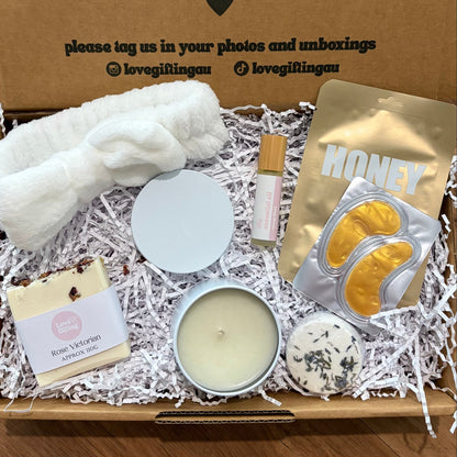 Pamper Self care Gift box with candles, soap, and other items on a wooden surface