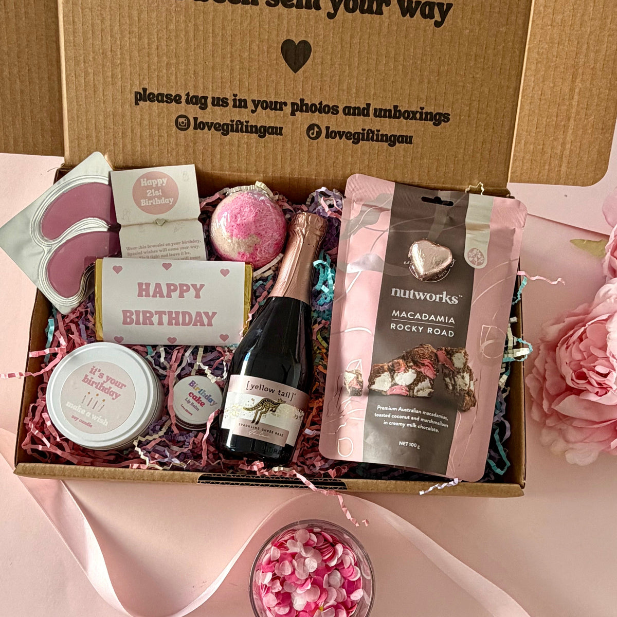  60th birthday gift box full of rocky road, prosecco, candle, bath bomb, 60th bracelet, under eye mask, and birthday cake lipbalm. Choice of sparkle claw clip or chocolate