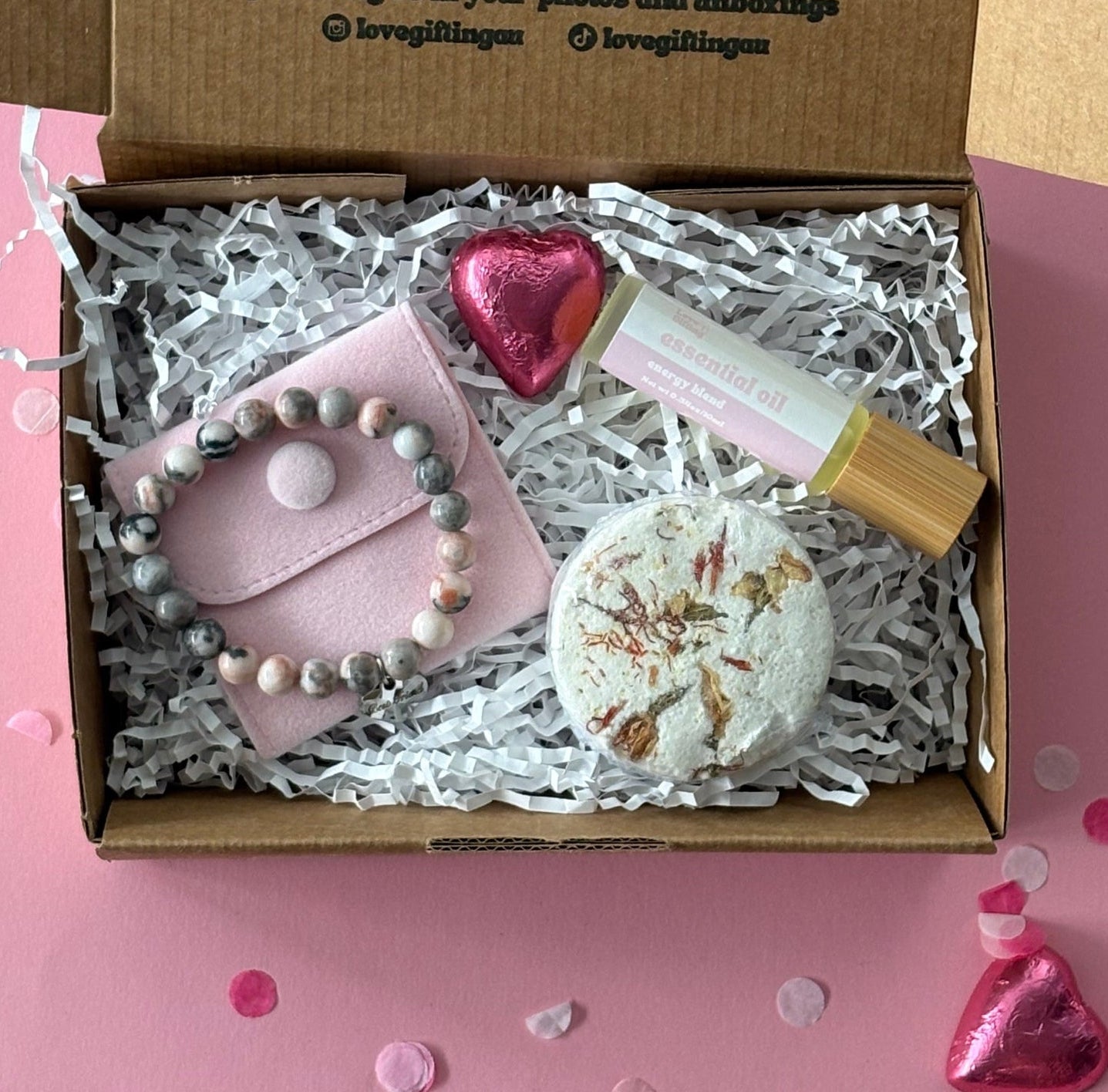 Gift box with stationery items on a pink background