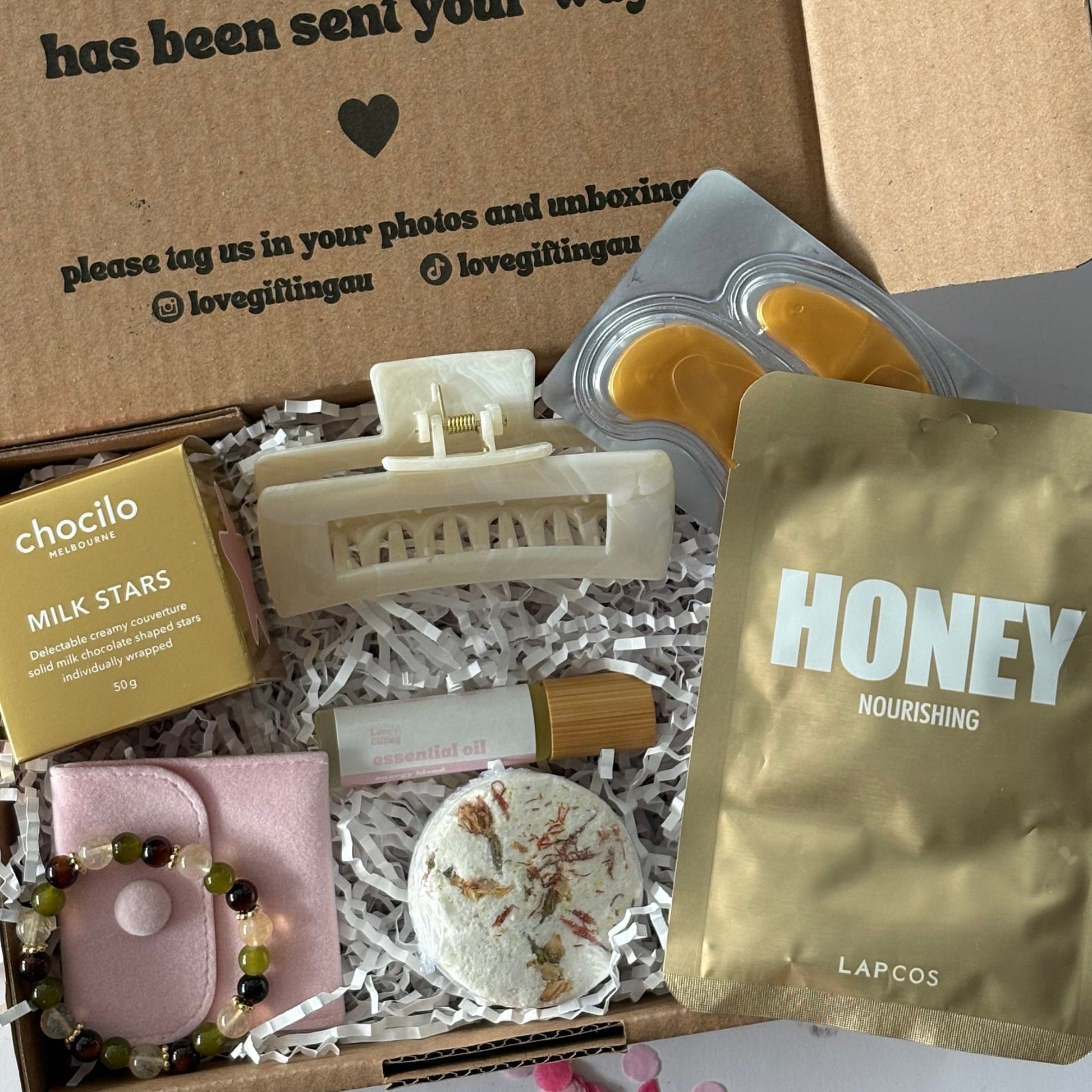 Menopause gift set including menopause bracelet, hair clip, energy roller, steamer, chocolate stars, facemask sheet and under eye mask