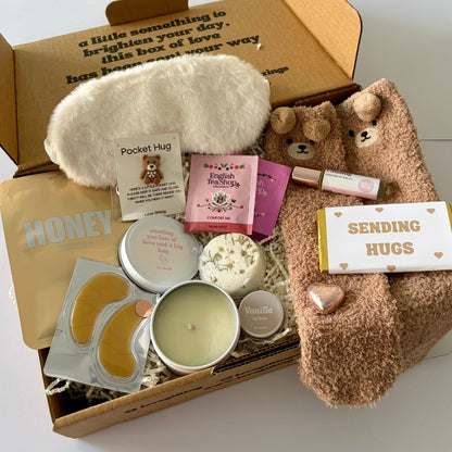 comfort gift box, includes facemask, bear socks, chocolate bar, comfort roller, candle, steamer , pocket hug token, lipbalm, candle and sleep mask