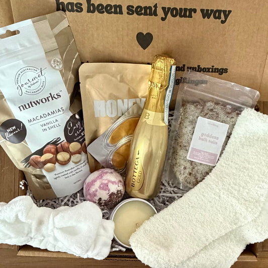 Gift box with champagne, snacks, and a sock, featuring a message of affection.