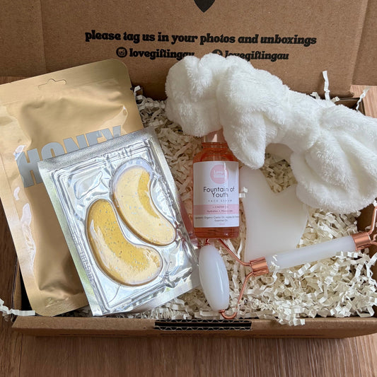 Gift box with self-care items on a wooden surface