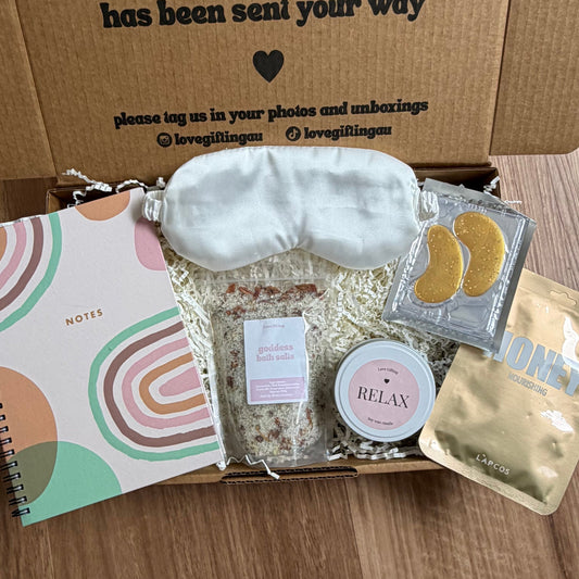Box of self-care items with a message on a wooden surface