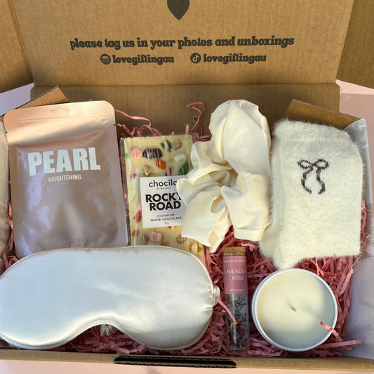 Gift box with skincare products, a candle, and a satin sleep mask . bath shot amf lapcs fa.ce sheet mask