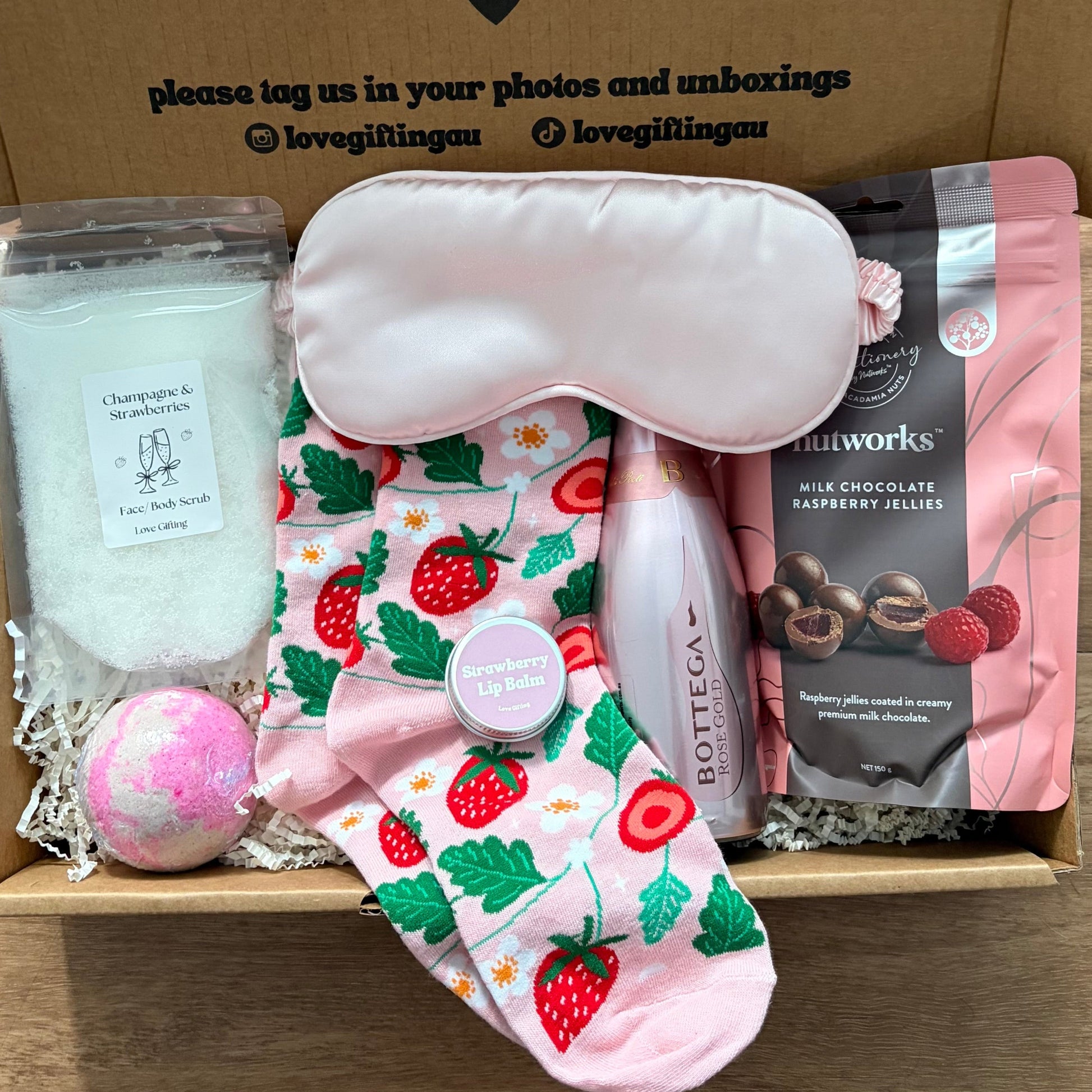 Gift box with sleep mask, socks, and chocolate, featuring a message on the lid.