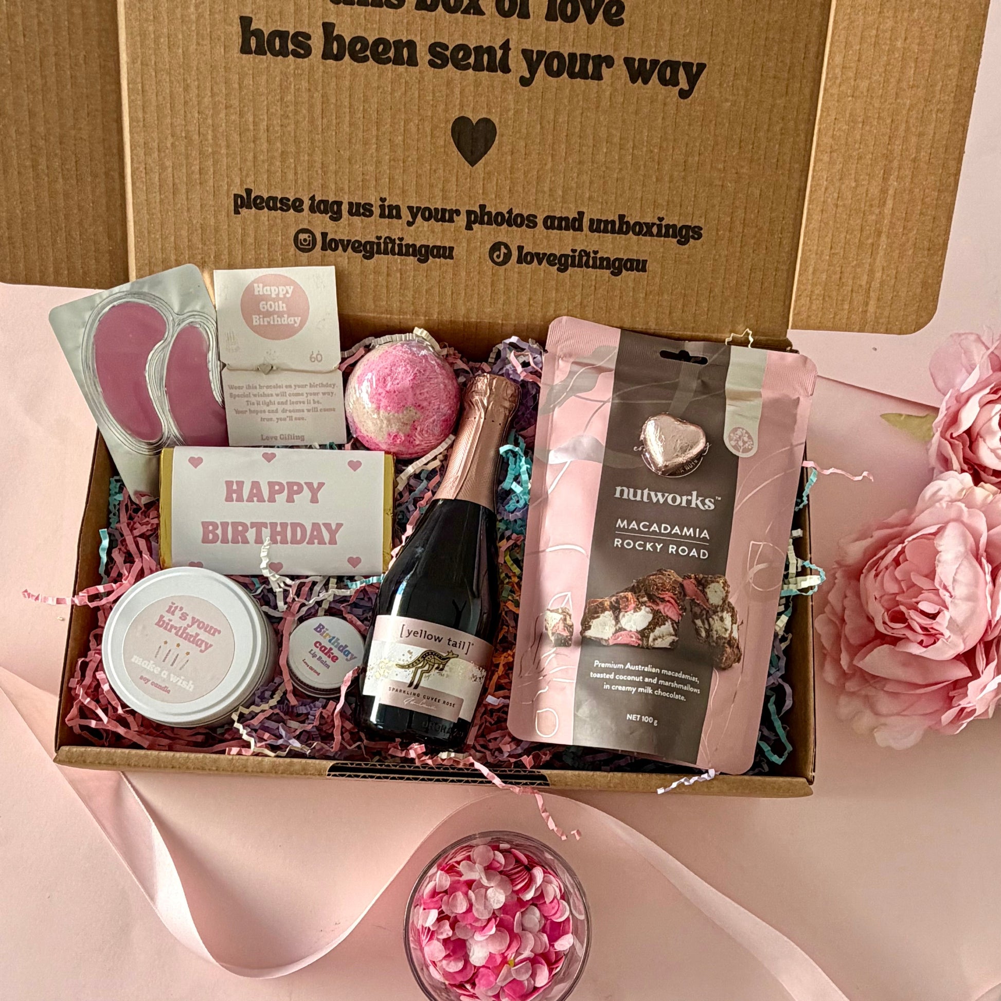  60th birthday gift box full of rocky road, prosecco, candle, bath bomb, 60th bracelet, under eye mask, and birthday cake lipbalm. Choice of sparkle claw clip or chocolate
