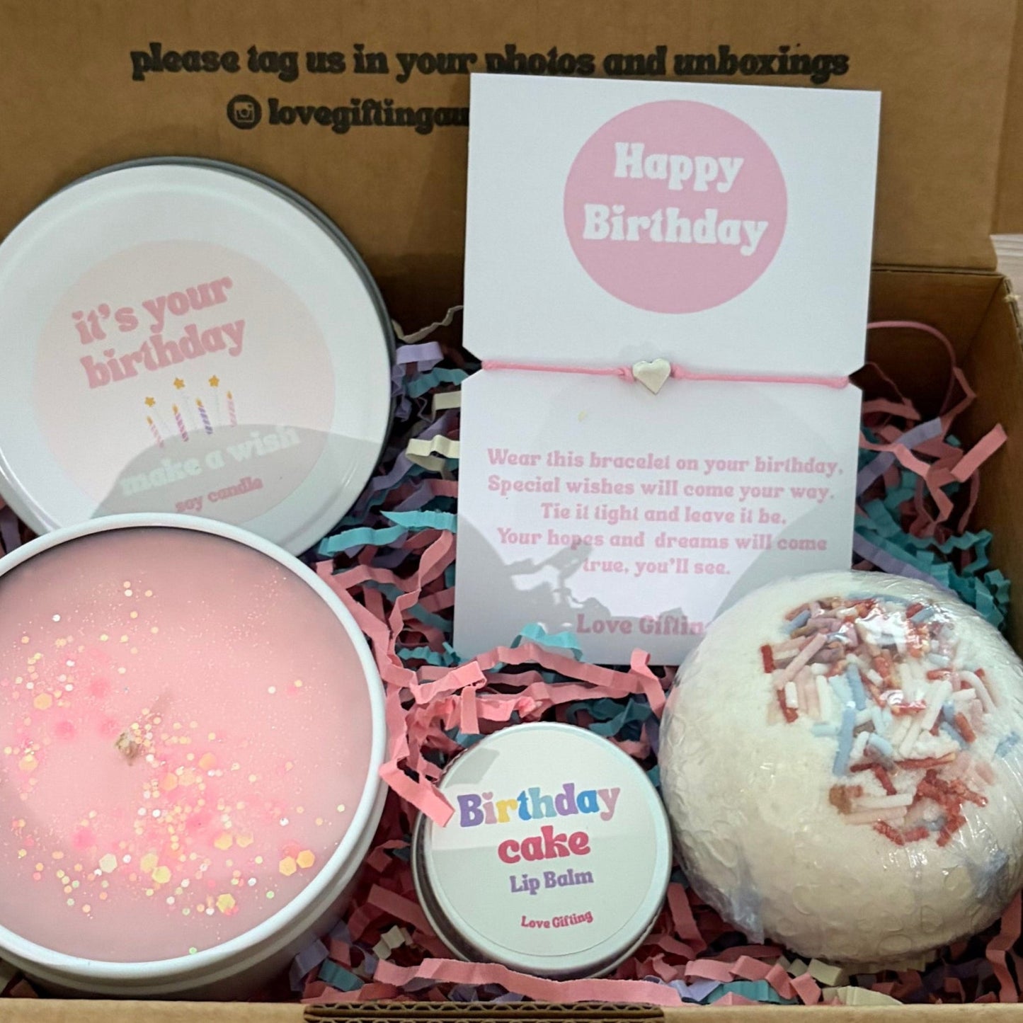 Birthday Gift box with candles, bath bomb, and card on a wooden surface
