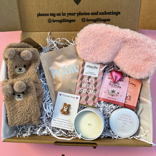 Get well soon gift box with pink fluffy eye mask, face mask sheet , bear hug token, candle, tea and chocolate