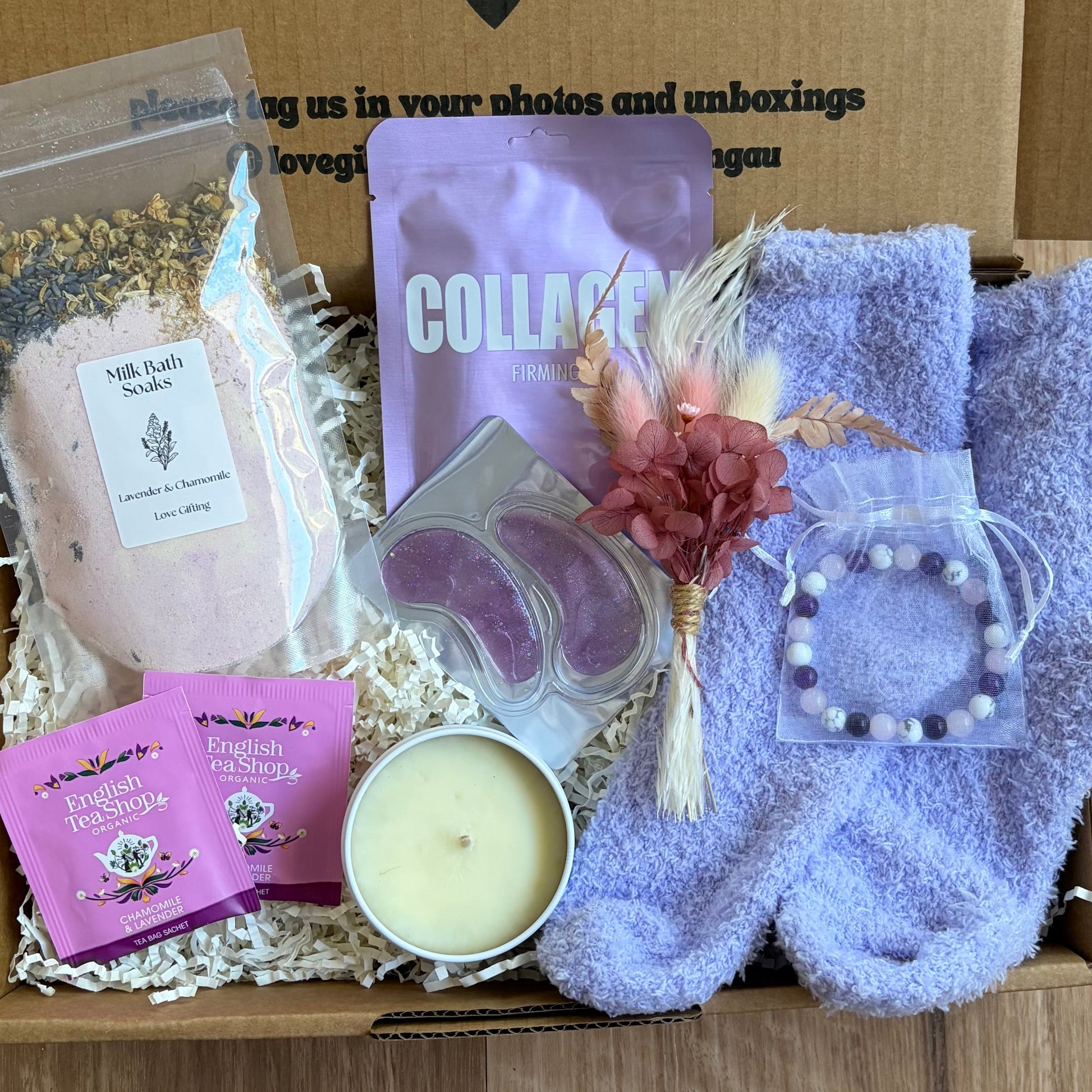 Box of self-care items including socks, soap, and a candle with a message on the box.