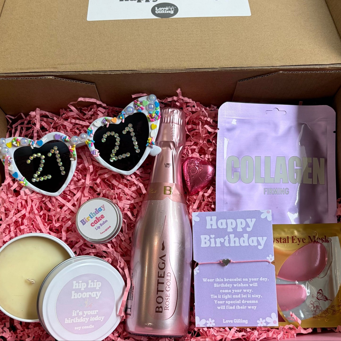 Gift box with birthday-themed items including a bottle, sunglasses, and collagen packaging.