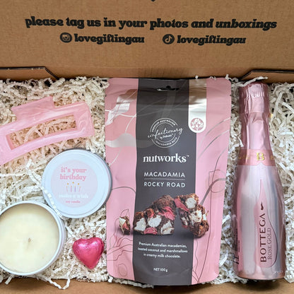 Gift box with a bottle of Prosecco, macadamia rocky road, and a candle, with a message on the lid.