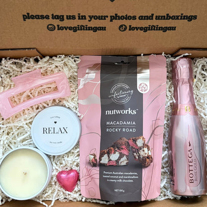 Gift box with a bottle, candle, and macadamia rocky road, featuring a message of encouragement.