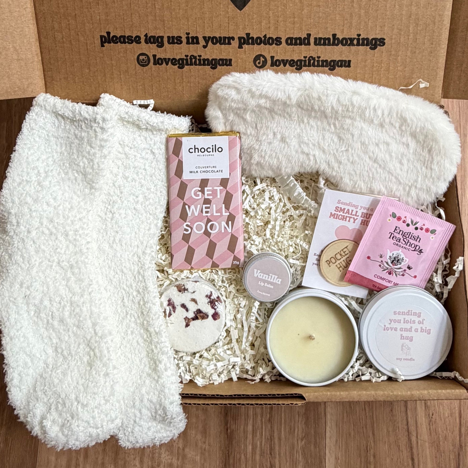 Box of self-care items with a message on a wooden surface