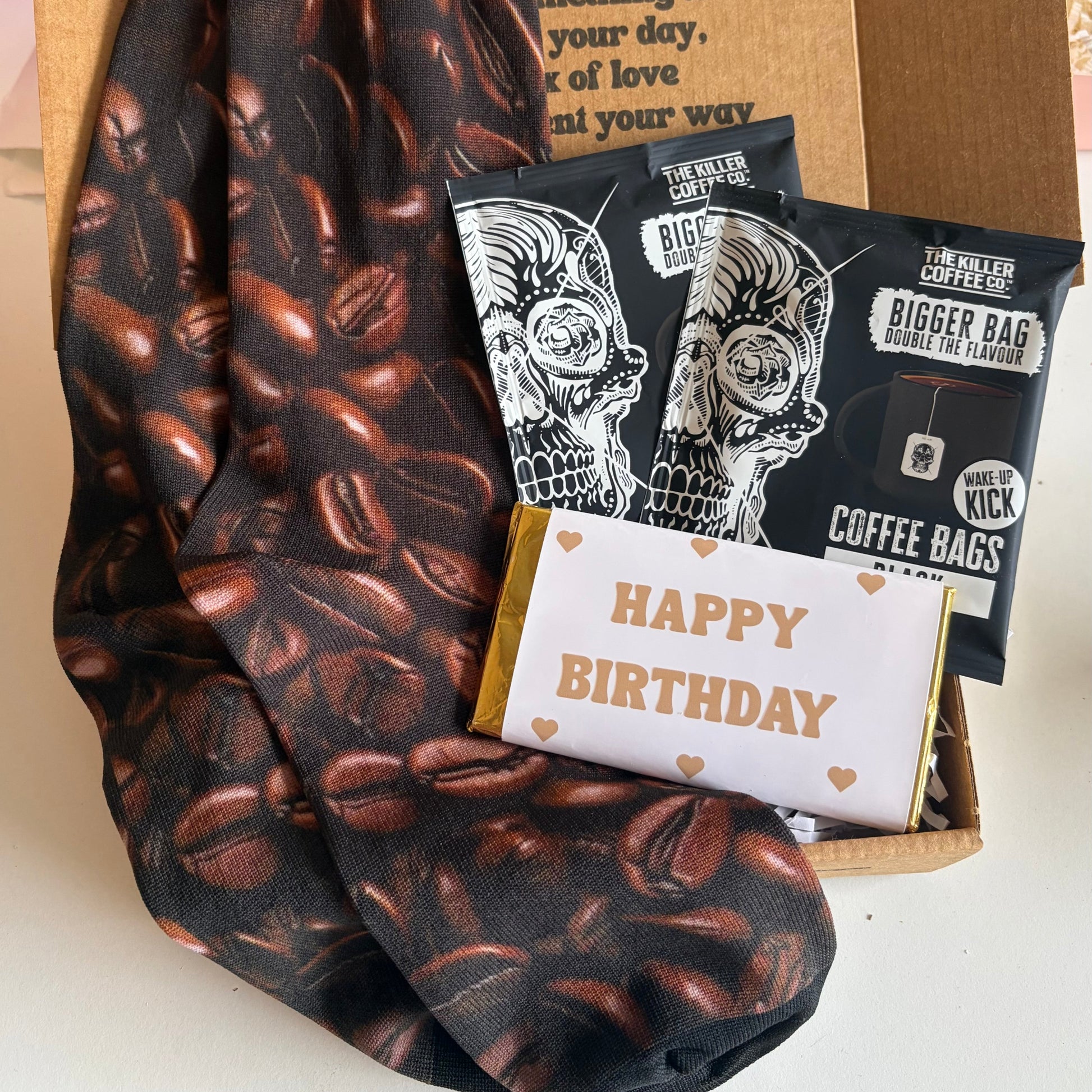 Coffee-themed socks and gift items including coffee bags and a birthday card on a white surface.