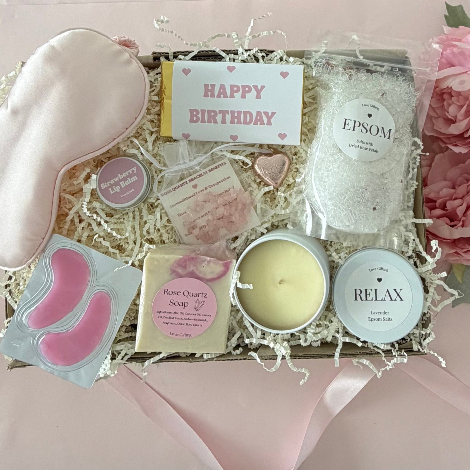 Pamper gift box includes epsom bath slats, sleep mask, under eye mask, candle, rose quartz soap, rose quartz bracelet, strawberry lipbalm, chocolate heart, happy birthday chocolate