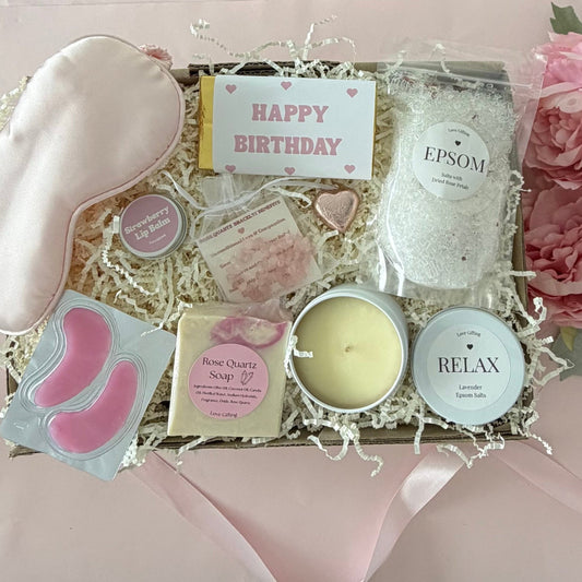 Pamper gift box includes epsom bath slats, sleep mask, under eye mask, candle, rose quartz soap, rose quartz bracelet, strawberry lipbalm, chocolate heart, happy birthday chocolate