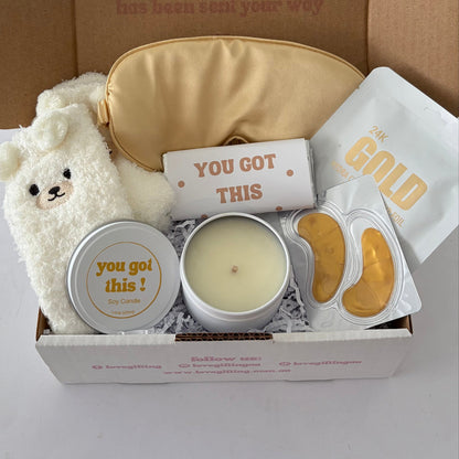 You've Got This Golden Comfort Gift Box by Love Gifting featuring cream teddy bear, gold satin sleep mask, soy candle, chocolate bar and gold skincare treats.