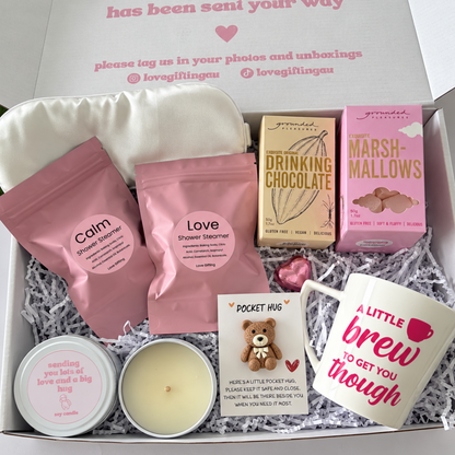 Comfort and hugs gift box for her featuring hot chocolate, marshmallows, ceramic mug, Japanese Honeysuckle candle, shower steamers and bear pocket hug.