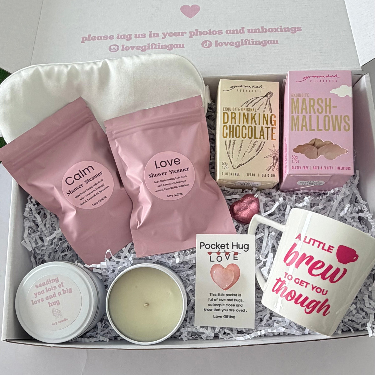 Comfort and hugs gift box for her featuring hot chocolate, marshmallows, ceramic mug, Japanese Honeysuckle candle, shower steamers and bear pocket hug.