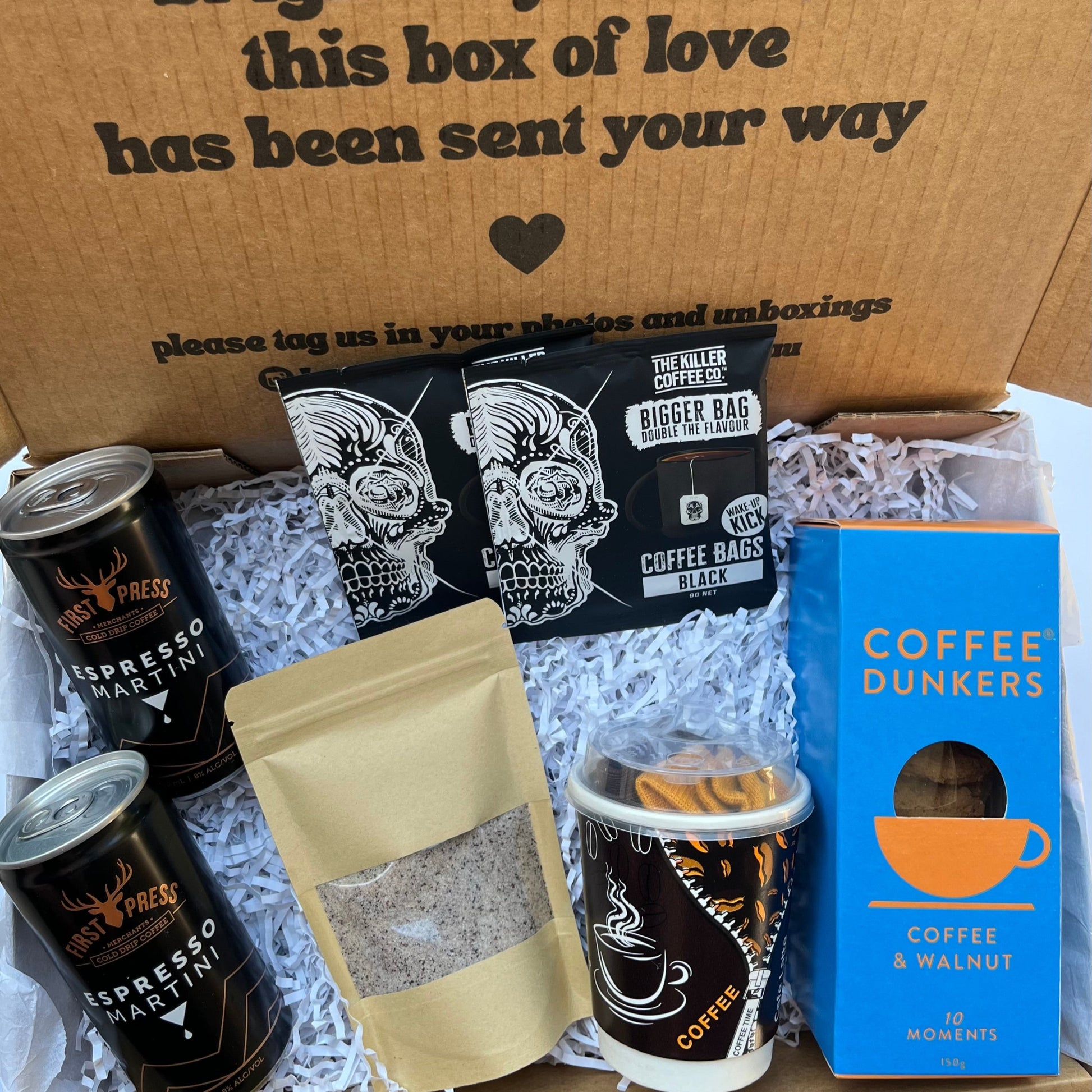 Coffee gift set with various coffee products and a message on a cardboard box.