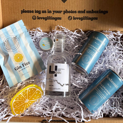 Gift box with a bottle of gin, tonic, and lemon slice, featuring a message on the lid.