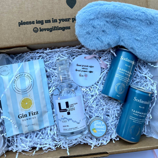 Gin and tonic gift set with a bottle of gin, tonic water, and gummies in a box.