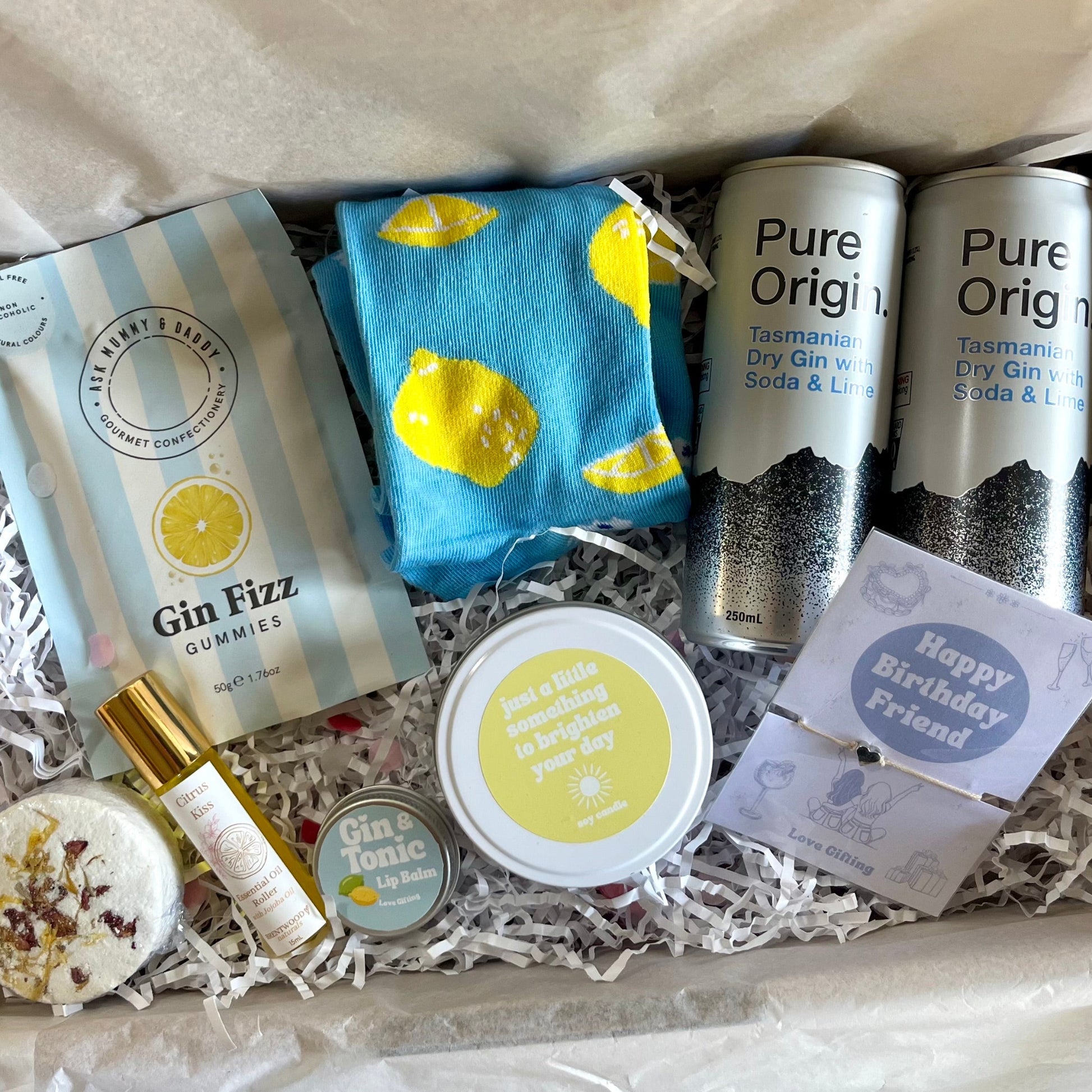 Gift box with gin-themed items including gummies, a bottle, and a card.