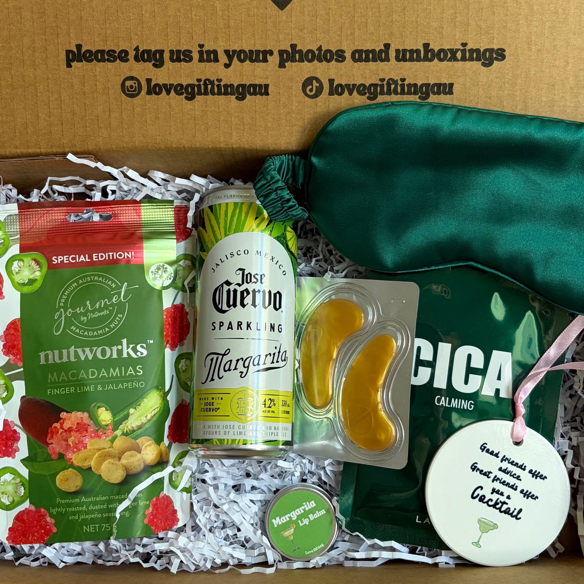 Cocktail Gift box with snacks, a bottle, and a green bag on a white background