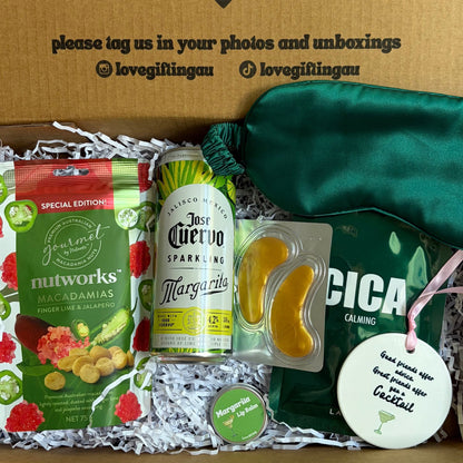 Cocktail Gift box with snacks, a bottle, and a green bag on a white background