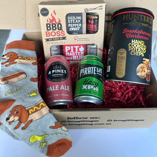 Gift box with beer bottles, snacks, and a can of sardines on a white background